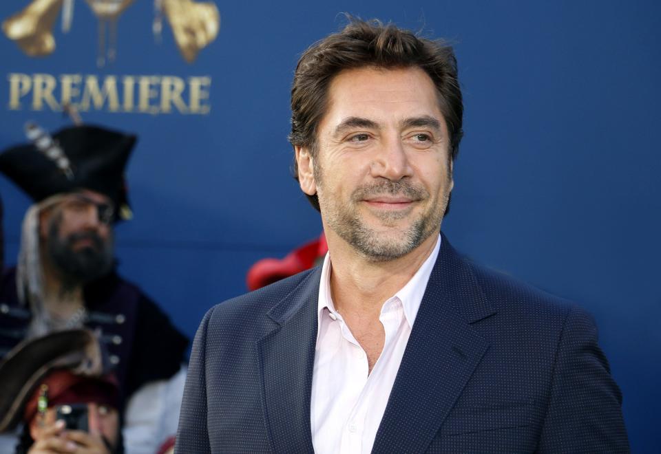 Javier smiling in a suit in front of a backdrop.