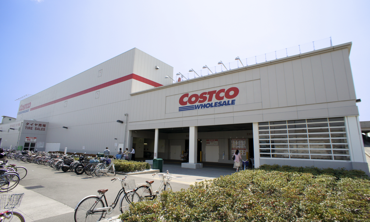 Exterior of Costco Wholesale building in Japan with bicycles and hedges in the foreground.