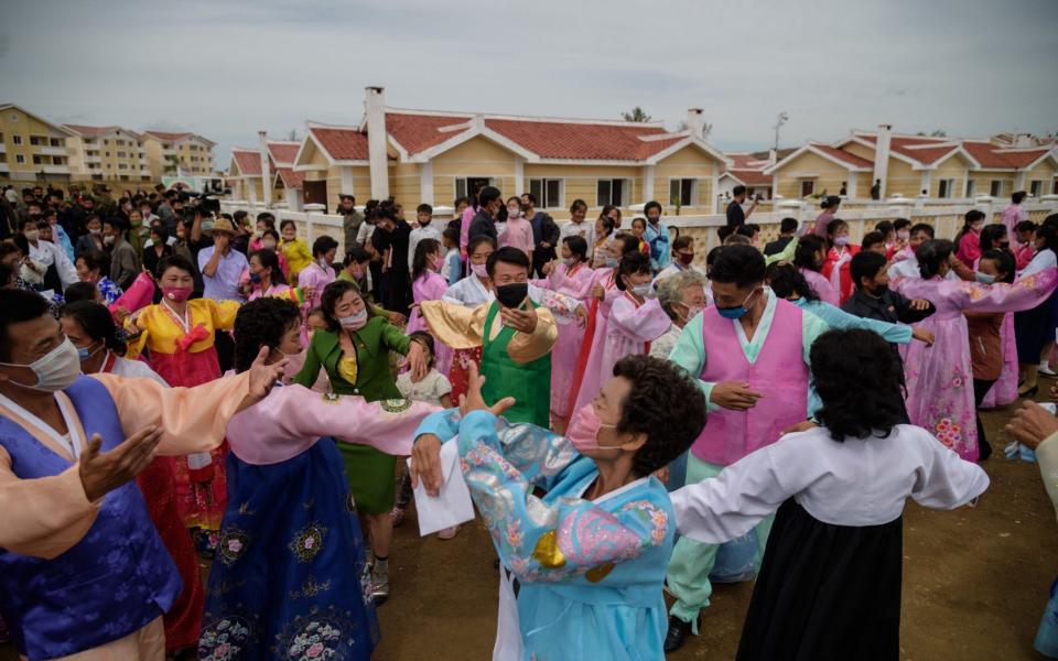 North Koreans dance to celebrate new housing licences - Kim Won Jin/AFP