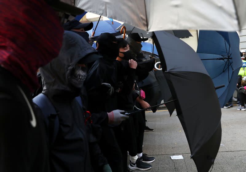 Anti-government protesters hold umbrellas as they attend the "Lest We Forget" rally in Hong Kong