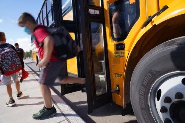 A student descends from a school bus in Ottawa last August. On Friday, the city's medical officer of health warned that it's likely schools will stay shut after spring break due to rising COVID-19 cases. (Francis Ferland/CBC - image credit)