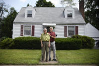 In this Saturday, July 17, 2021, photo, Fred Ware, left, stands outside his home with his son Dave Ware in Manchester, Conn. Fred and Dave Ware recently found a whites-only covenant on his property dating back to 1942 when researching the title chain. Upon finding the covenant, Dave Ware, who grew up in the home, reached out to state lawmakers and helped get a bill passed that strips these covenants on properties. (AP Photo/Jessica Hill)
