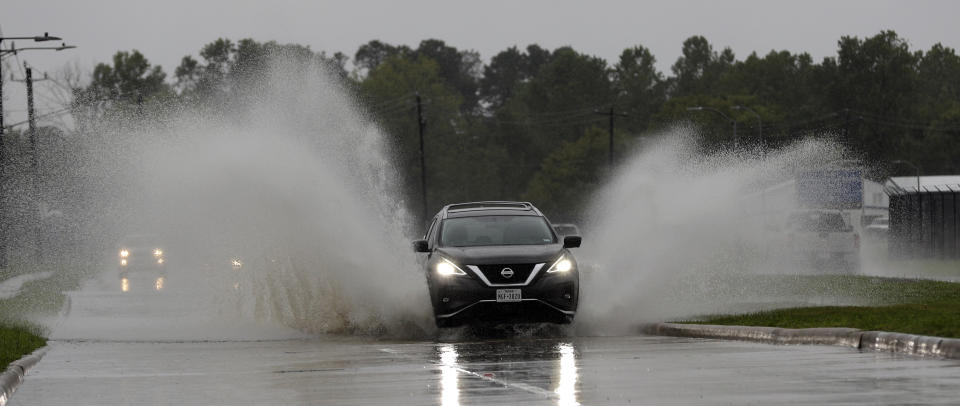 A car drives through floodwaters from Tropical Depression Imelda Wednesday, Sept. 18, 2019, in Houston. (AP Photo/David J. Phillip)