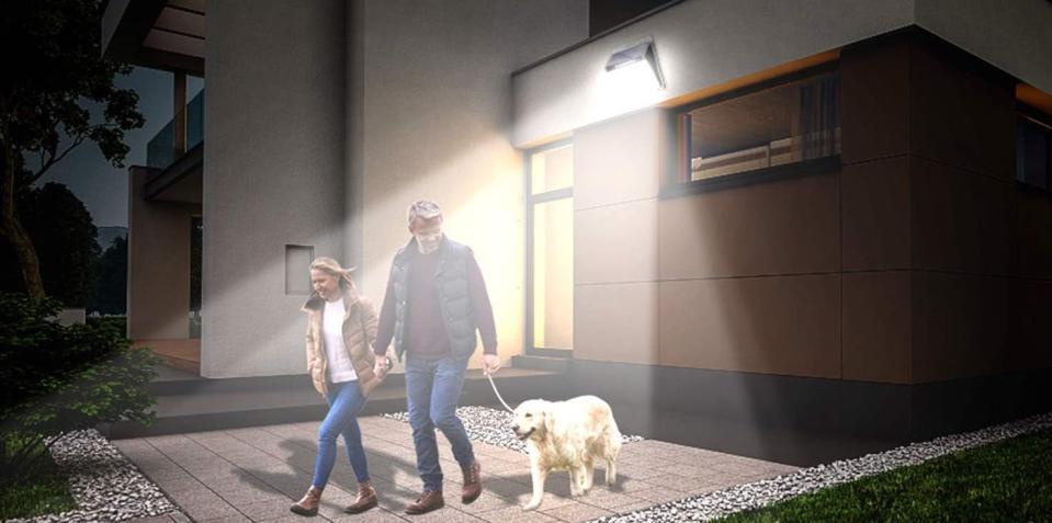 Mockup of couple walking their dog outside of a modern house at night by the light of a bright motion-sensor light