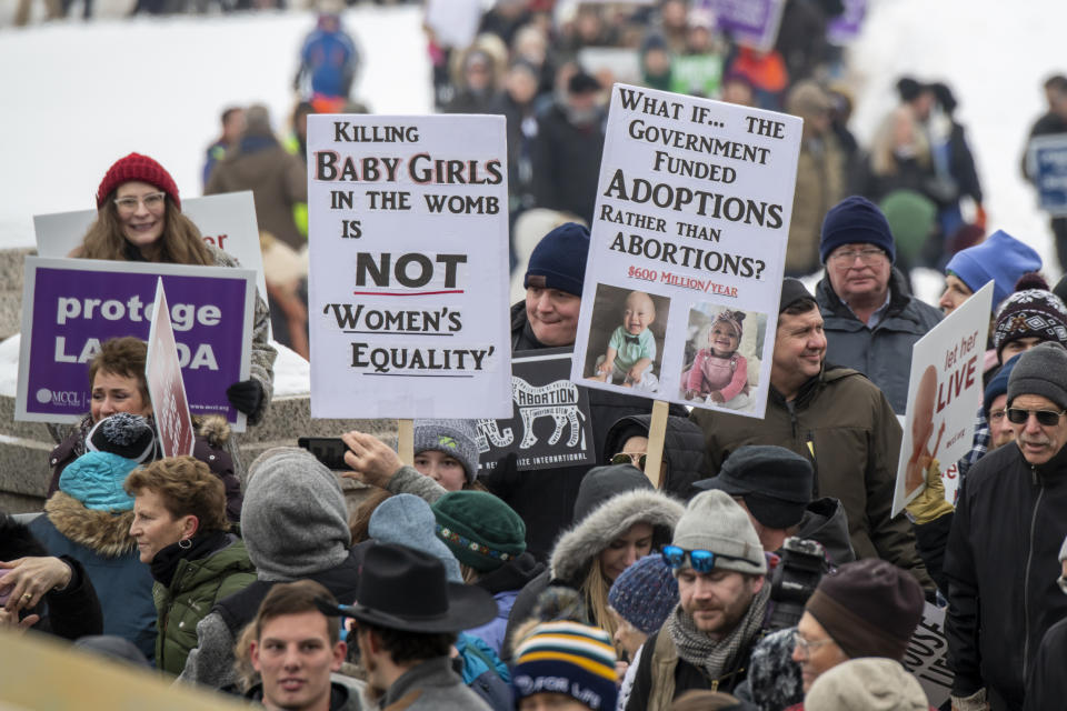 Protesters at an anti-abortion rally in St. Paul, Minn., hold signs that read: Killing baby girls in the womb is not women's equality, and what if the government funded adoptions rather than abortions.