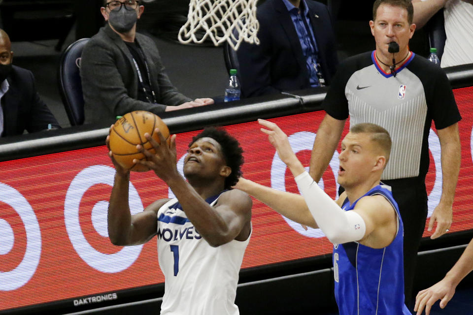 Minnesota Timberwolves forward Anthony Edwards, left, shoots in front of Dallas Mavericks center Kristaps Porzingis, right, in the first quarter during an NBA basketball game, Sunday, May 16, 2021, in Minneapolis. (AP Photo/Andy Clayton-King)