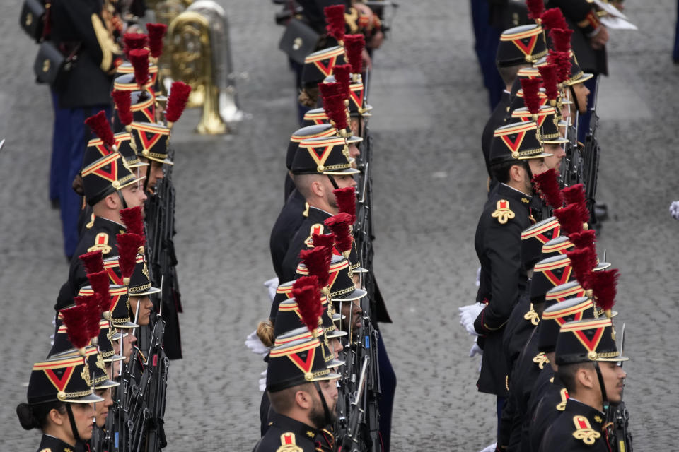 The Republican Guard soldiers stand prior to the start of the Bastille Day parade on the Champs-Elysees avenue in Paris, Friday, July 14, 2023. (AP Photo/Christophe Ena)