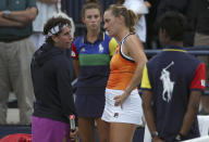 Carla Suarez Navarro, of Spain, left, talks with Timea Babos, of Hungary, after retiring from the match after the first set during the first round of the US Open tennis tournament Tuesday, Aug. 27, 2019, in New York. (AP Photo/Eduardo Munoz Alvarez)