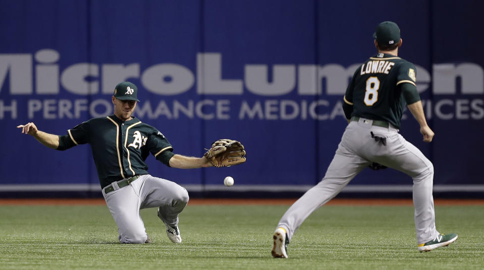 Oakland Athletics right fielder Stephen Piscotty and second baseman Jed Lowrie (8) can't get to a single by Tampa Bay Rays' Mallex Smith during the first inning of a baseball game Friday, Sept. 14, 2018, in St. Petersburg, Fla. (AP Photo/Chris O'Meara)