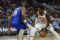 New York Knicks forward Julius Randle (30) looks for opening against Orlando Magic center Wendell Carter Jr. (34) during the first half of an NBA basketball game, Thursday, March 23, 2023, in Orlando, Fla. (AP Photo/Kevin Kolczynski)
