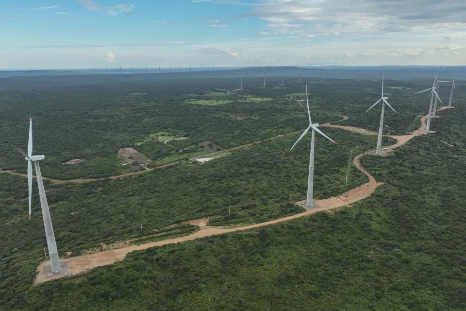 Wind turbines operate in Lagoa, Brazil, Thursday, March 14, 2024. Wind energy is booming in Brazil's Northeast, but some projects are drawing criticism as it becomes clear that certain communities have benefited while others have not. (AP Photo/Andre Penner)