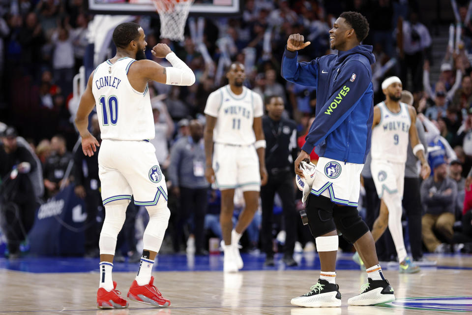 Minnesota Timberwolves guard Mike Conley (10) and guard Anthony Edwards, right, celebrate after Conley's 3-point basket during the second half of the team's NBA basketball game against the Memphis Grizzlies on Thursday, Jan. 18, 2024, in Minneapolis. (AP Photo/Matt Krohn)