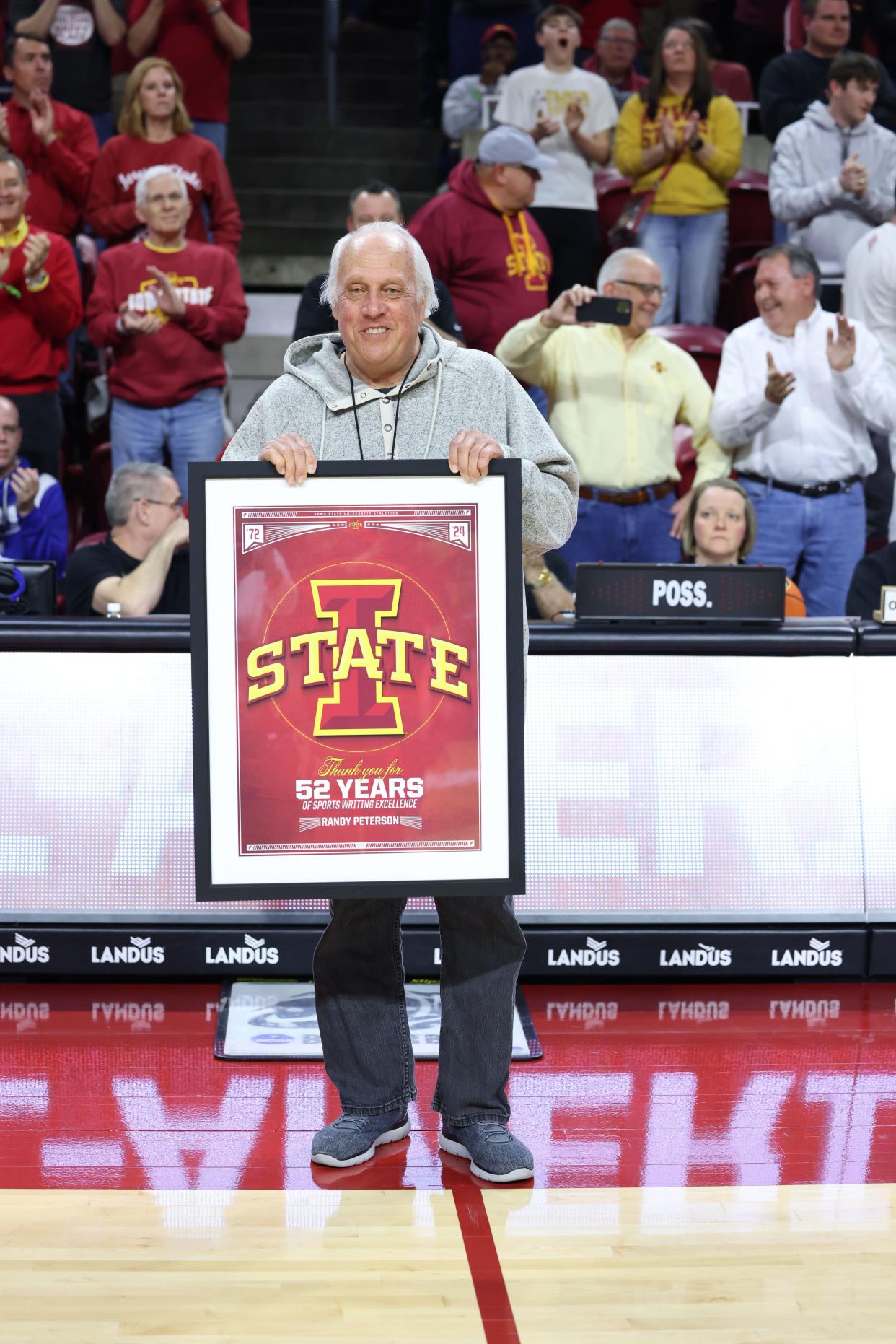Des Moines Register sports columnist Randy Peterson is honored before the Iowa State vs. BYU men's basketball game at Hilton Coliseum in Ames on March 6. Peterson recently retired after a 52-year career at the Register.