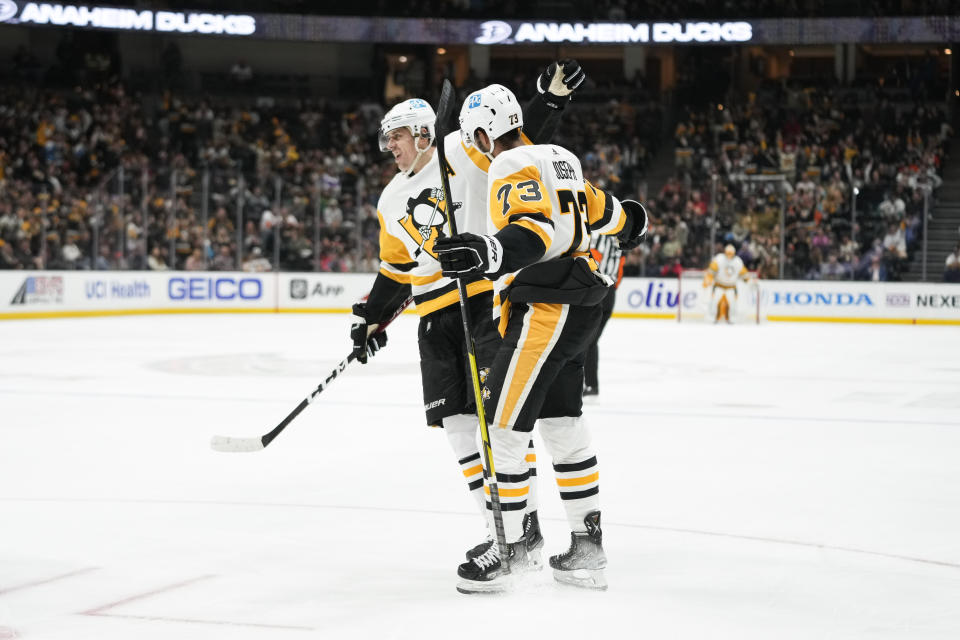 Pittsburgh Penguins' Pierre-Olivier Joseph (73) and Evgeni Malkin (71) celebrate after a goal by Joseph during the second period of an NHL hockey game against the Anaheim Ducks, Friday, Feb. 10, 2023, in Anaheim, Calif. (AP Photo/Jae C. Hong)