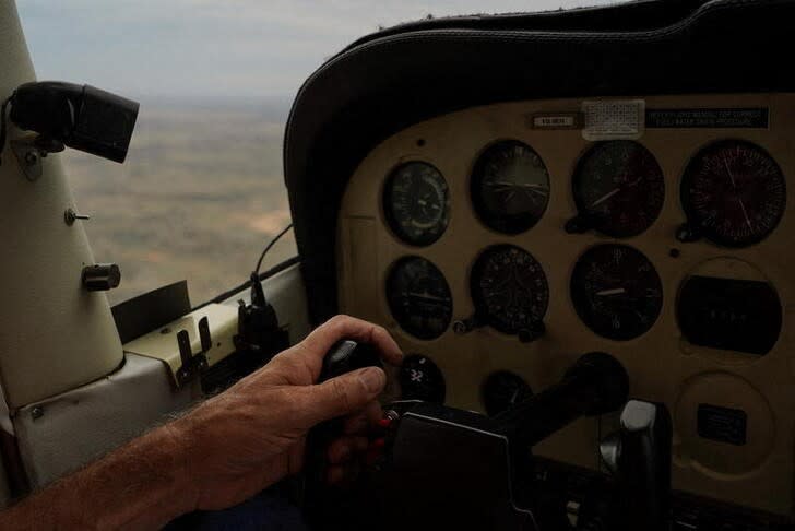 Wider Image: Una oración desde el cielo: pastor australiano que pilota sobre el campo despega de nuevo