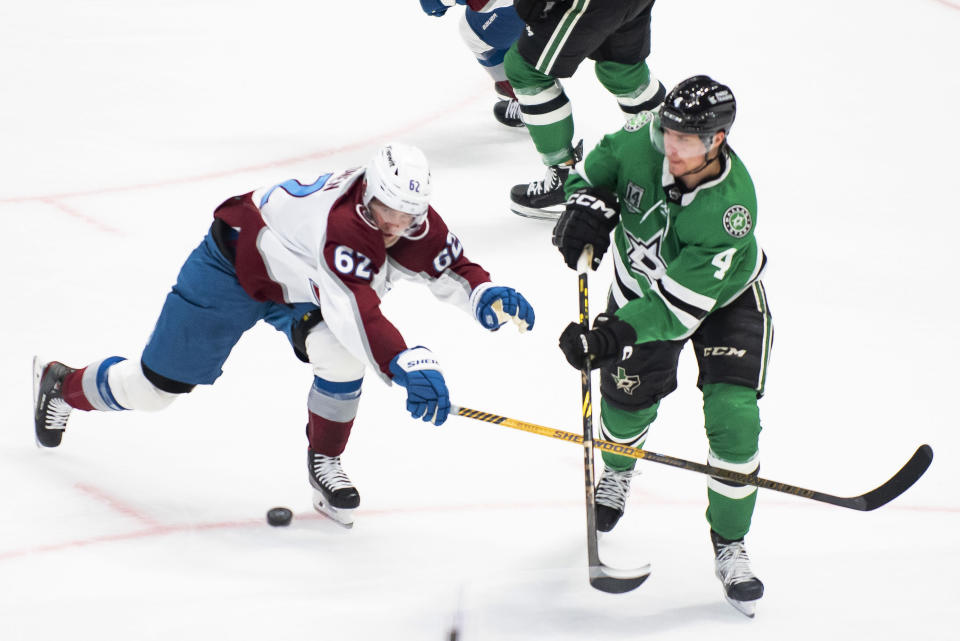 Dallas Stars defenseman Miro Heiskanen (4) passes the puck downice as Colorado Avalanche left wing Artturi Lehkonen (62) attempts to steal the puck during the first period of an NHL hockey game, Saturday, March 4, 2023, in Dallas. (AP Photo/Emil T. Lippe)