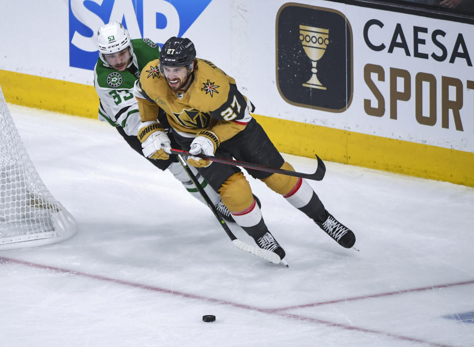 Vegas Golden Knights defenseman Shea Theodore (27) is pursued by Dallas Stars center Wyatt Johnston (53) during the second period of Game 1 of the NHL hockey Stanley Cup Western Conference finals Friday, May 19, 2023, in Las Vegas. (AP Photo/Sam Morris)