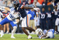 Virginia wide receiver Suderian Harrison (1) avoids a tackle by Duke special teams player Nick Lampert (4) on a punt return during the first half of an NCAA college football game Saturday, Nov. 18, 2023, in Charlottesville, Va. (AP Photo/Mike Caudill)