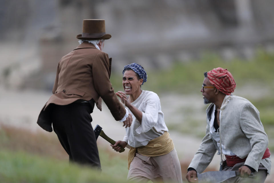 Reenactors acting as slaves attack a slave owner during a performance artwork reenacting the largest slave rebellion in U.S. history, in LaPlace, La., Friday, Nov. 8, 2019. The reenactment was conceived by Dread Scott, an artist who often tackles issues of racial oppression and injustice. Scott says that those who took part in the rebellion were "heroic" and that the rebellion is something that people should know about and be inspired by. (AP Photo/Gerald Herbert)