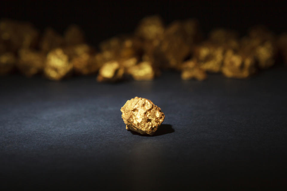 A gold nugget in front of other gold nuggets