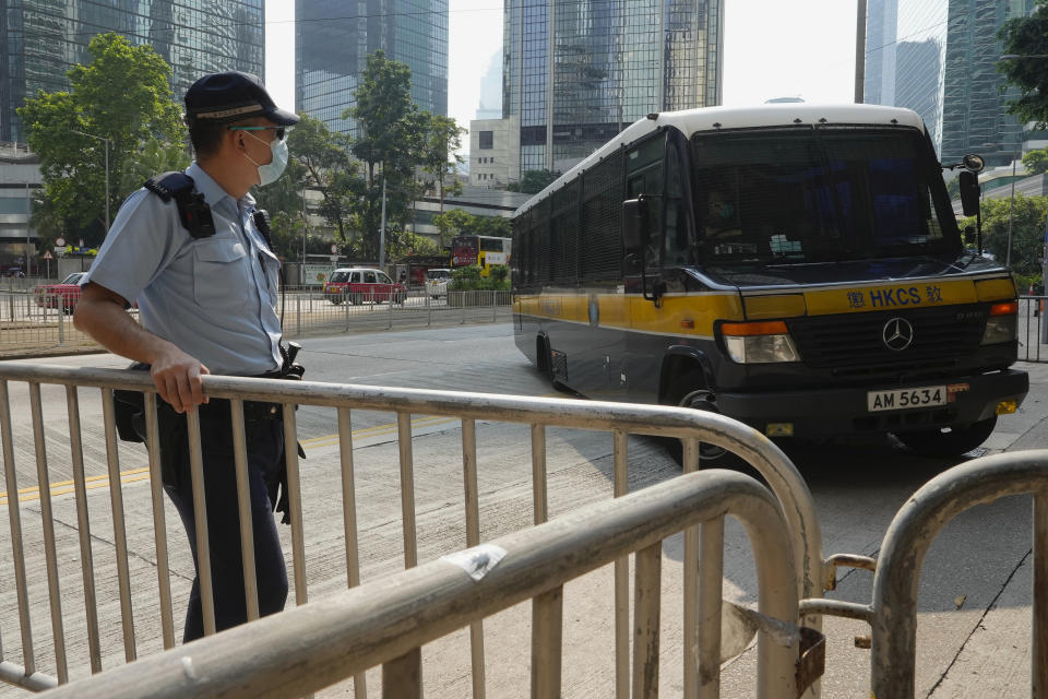 A prison van, right, which a police officer says is carrying Tong Ying-kit arrives at a court in Hong Kong Tuesday, July 27, 2021. Hong Kong High Court will deliver verdict in the afternoon for the first person charged under Hong Kong's National Security Law. Tong was arrested in July 2020 after driving his motorbike into a group of police officers while carrying a flag bearing the protest slogan “Liberate Hong Kong." He was charged with inciting separatism and terrorism. (AP Photo/Vincent Yu)