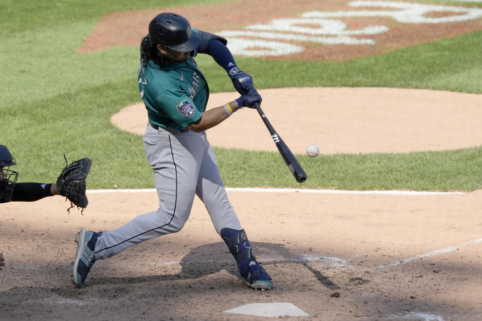 Seattle Mariners' Eugenio Suarez hits a two-run single during the ninth inning of a baseball game against the Chicago White Sox, Wednesday, Aug. 23, 2023, in Chicago. (AP Photo/Charles Rex Arbogast)