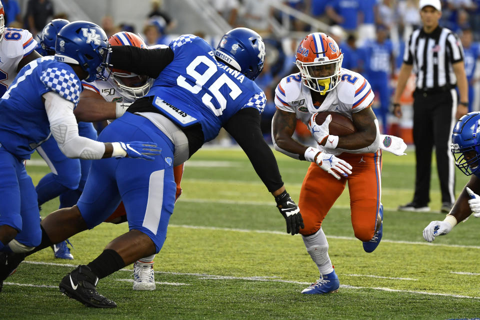 Florida running back Lamical Perine (2) runs through an opening in the Kentucky line as Kentucky nose tackle Quinton Bohanna (95) closes in during the first half of an NCAA college football game in Lexington, Ky., Saturday, Sept. 14, 2019. (AP Photo/Timothy D. Easley)