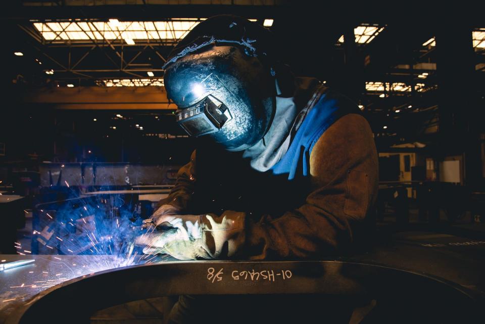 A welder works on a U.S. Navy ship at a steel production facility. (Ashley Cowan/Newport News Shipbuilding)