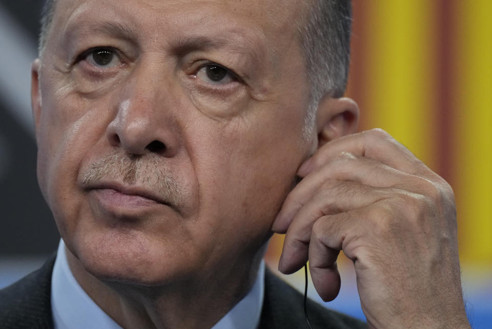 Turkish President Recep Tayyip Erdogan adjusts his earpiece as he listens to a question from a journalist during a media conference at a NATO summit in Madrid, Spain on Thursday, June 30, 2022. North Atlantic Treaty Organization heads of state met for the final day of a NATO summit in Madrid on Thursday. (AP Photo/Manu Fernandez)