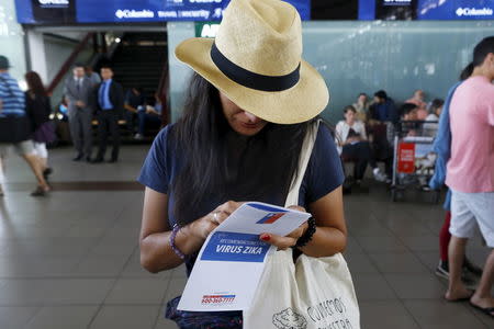 A woman holds a zika virus flyer from an information campaign by the Chilean Health Ministry at the departures area of Santiago's international airport, Chile January 28, 2016. The flyer reads: "Zika virus recommendations." REUTERS/Ivan Alvarado -