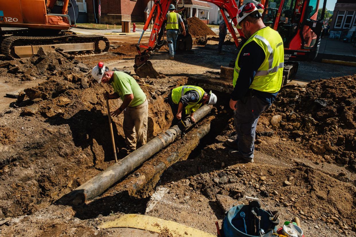 Workers from Enbridge Gas Ohio clean up the exterior of a punctured gas main at the intersection of Grant and North Third streets in Dennison where workers struck the 8-inch line.