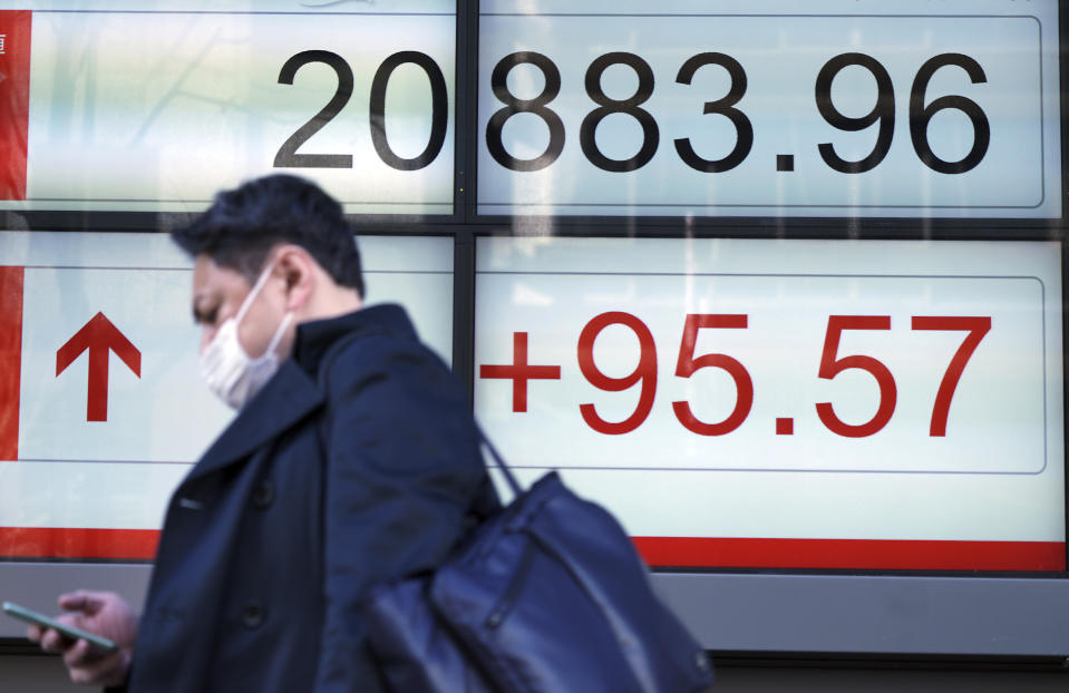 A man walks past an electronic stock board showing Japan's Nikkei 225 index at a securities firm in Tokyo Monday, Feb. 4, 2019. Asian markets were mixed Monday as traders questioned an imminent meeting between American and Chinese officials to work on disagreements ranging from technology development to trade. (AP Photo/Eugene Hoshiko)