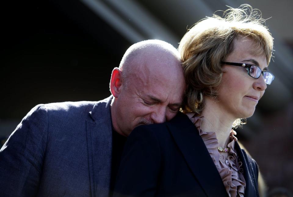 Kelly, crying, rests his head on Gabby Giffords' shoulder.