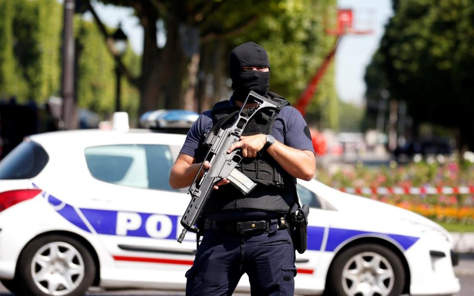 A masked French policeman secures the area on the Champs Elysees avenue after an incident in Paris, France - Credit: GONZALO FUENTES/ REUTERS