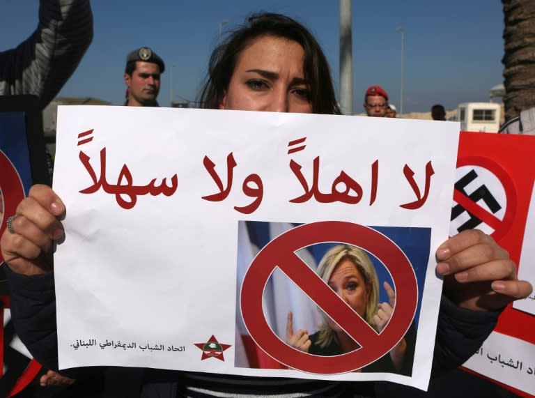 A Lebanese woman holds a "you are not welcome" placard as she demonstrates against a visit by France's far-right presidential candidate Marine Le Pen to Beirut, on February 21, 2017