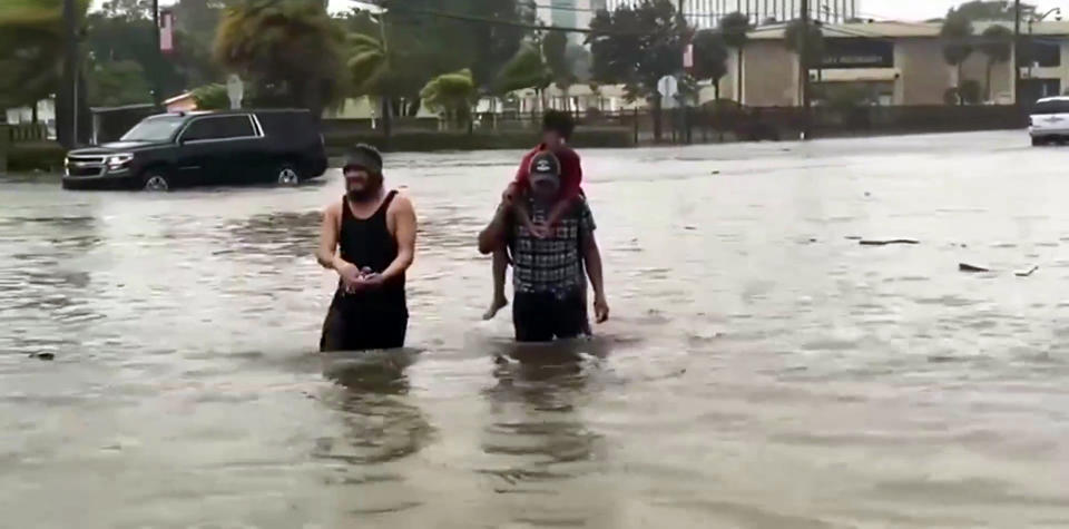 Residents of Fort Myers, Florida, make their way through floodwaters caused by Hurricane Ian. (NBC News)