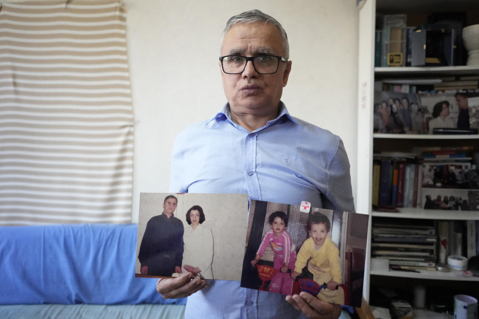 Narges Mohammadi's husband Taghi Rahmani shows a picture of him and his wife, and one of their children, Friday, Oct. 6, 2023 in Paris. Imprisoned Iranian activist Narges Mohammadi won the Nobel Peace Prize on Friday in recognition of her tireless campaigning for women's rights and democracy and against the death penalty. (AP Photo/Thibault Camus)