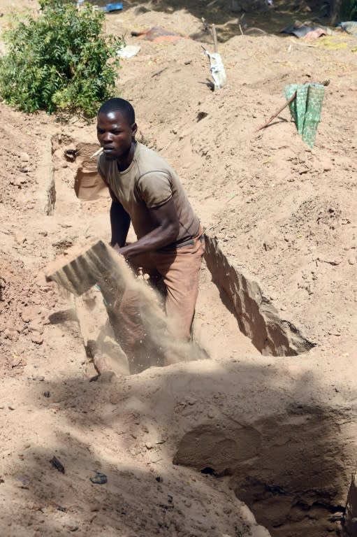 A man digs grave for victims or dead members of Boko Haram Islamists before their expected burial at Gwange Cemetery in Maiduguri, northeast Nigeria, on February 2, 2016