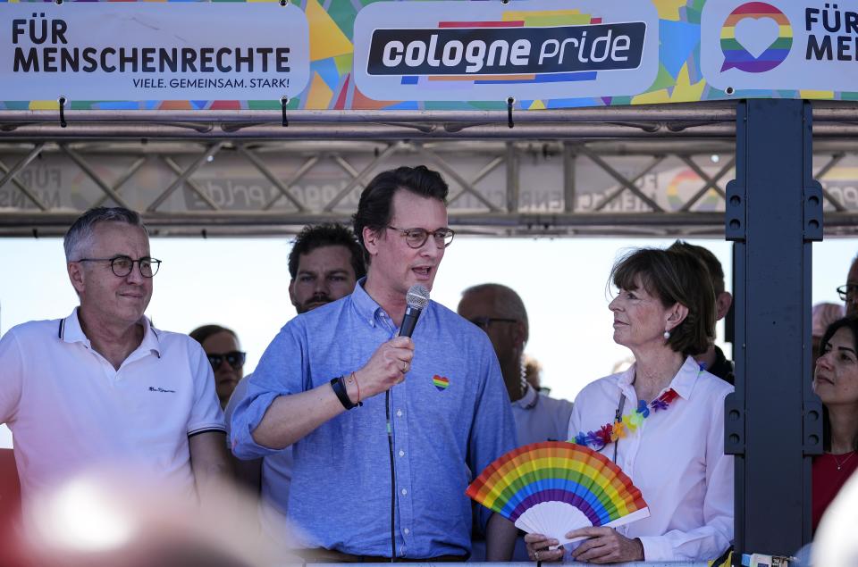 North Rhine-Westphalia minister president Hendrik Wuest, center, and Cologne Mayer Henriette Reker, right, giving a speech on a float at the opening of the Cologne Pride rally in Cologne, Germany, Sunday, July 3, 2022. This year's Christopher Street Day (CSD) Gay Parade with thousands of demonstrators for LGBTQ rights is the first after the coronavirus pandemic to be followed by hundreds of thousands of spectators in the streets of Cologne. (AP Photo/Martin Meissner)