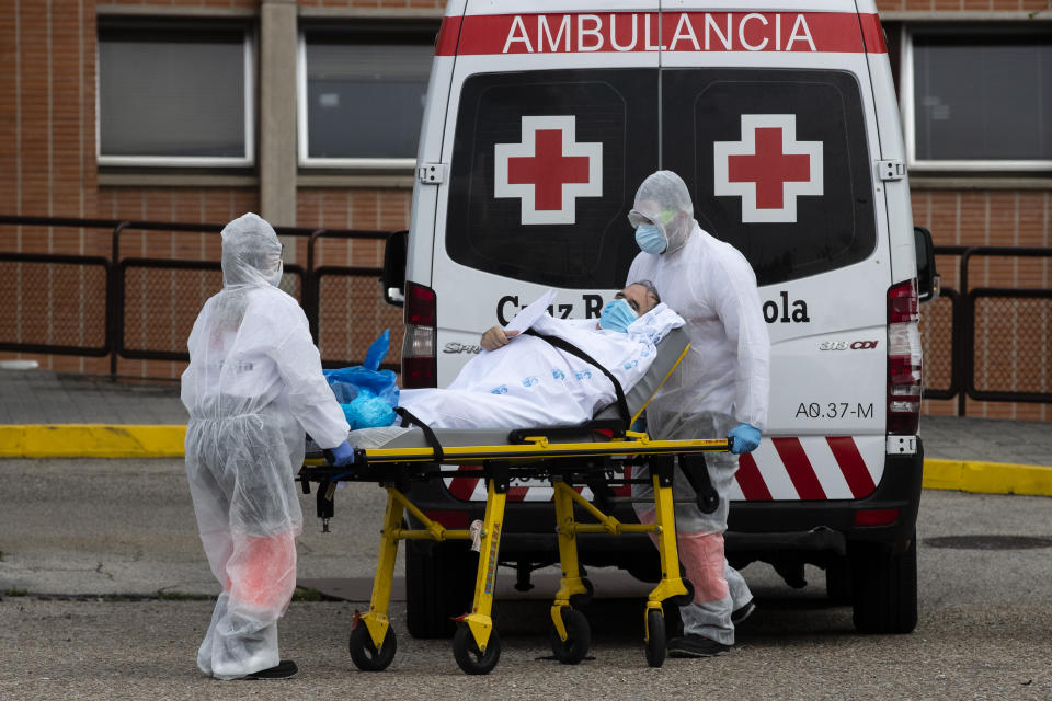 Emergency workers wearing full protective suits transport a patient to an ambulance at the Severo Ochoa Hospital in Leganes, Spain, Saturday, April 18, 2020. Spain has eased this week the conditions of Europe's strictest lockdown, allowing manufacturing, construction and other nonessential activity in an attempt to cushion the economic impact of the coronavirus pandemic. (AP Photo/Manu Fernandez)