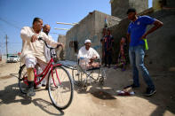 Rafed, a man disabled by a landmine explosion, rides his bicycle in the village of Bitr, which in Arabic means "amputation", in Al-Tanouma district, east of Basra, Iraq March 20, 2018. REUTERS/Essam Al-Sudani
