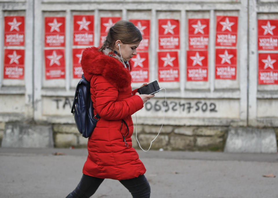 A girl walks by electoral posters advertising the candidates of the Socialists' Party in Chisinau, Moldova, Thursday, Feb. 21, 2019, ahead of parliamentary elections taking place on Feb. 24. Moldova's president says the former Soviet republic needs good relations with Russia, amid uncertainty about the future of the European Union. (AP Photo/Vadim Ghirda)