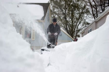 South Buffalo resident Ron Jeblonski uses a snow blower to clear snow from his driveway in South Buffalo, New York, November 22, 2014. REUTERS/Aaron Ingrao