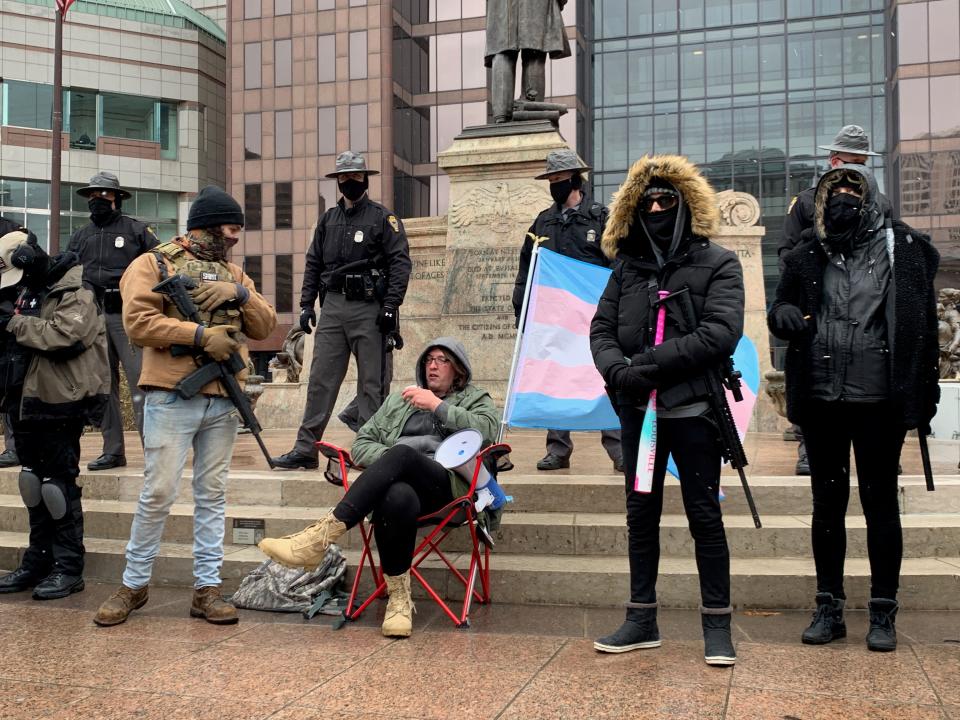 Dan Werts of Logan County, Ohio, speaks into a megaphone while sitting in front of the Ohio Statehouse in a chair with the Trans Pride flag attached on Sunday, Jan. 17, 2021. “Just a reminder, it was not antifa who raided the Capitol, it was Trump supporters,” Werts said. “You have the audacity to try and rewrite history and make yourselves look like the good guys. That’s pathetic.”