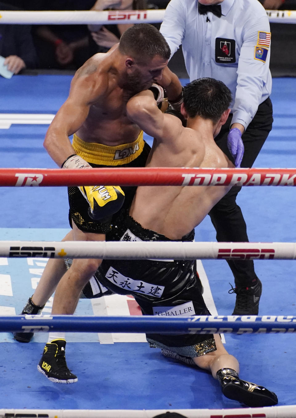 Vasiliy Lomachenko, of Ukraine, left, knocks down Masayoshi Nakatani, of Japan, during a lightweight bout Saturday, June 26, 2021, in Las Vegas. (AP Photo/John Locher)
