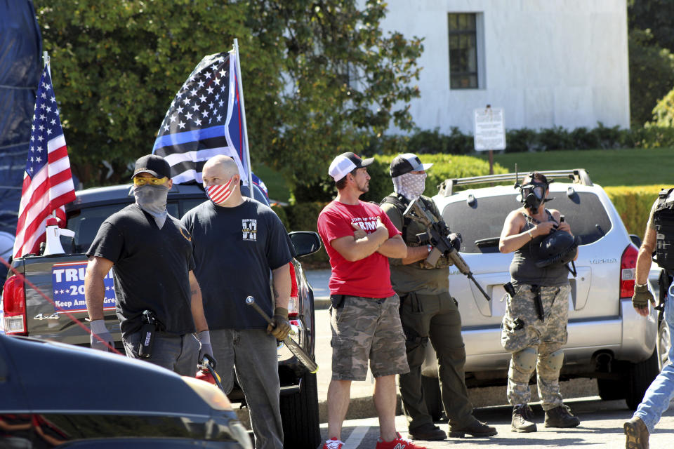 Armed right-wing protesters in support of President Donald Trump stand in front of the Oregon State Capitol in Salem, Ore., Monday, Sept. 7, 2020. Hundreds of people gathered on Labor Day in a small town south of Portland for a pro-President Donald Trump vehicle rally, just over a week after member of a far-right group was fatally shot after a Trump caravan went through Oregon's largest city. Later, pro-Trump supporters and counter-protesters clashed at Oregon's Capitol. (AP Photo/Andrew Selsky)