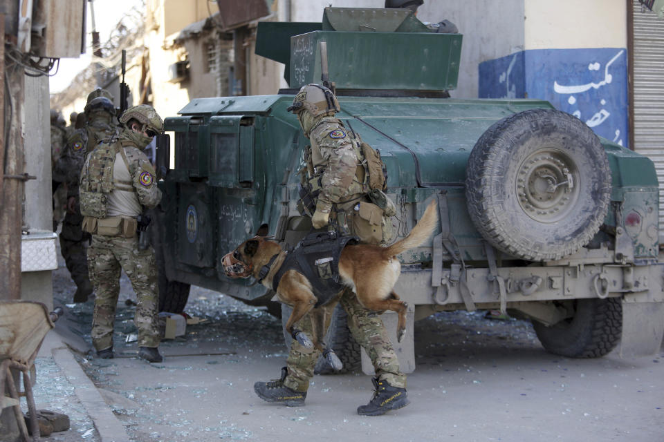 Foreign troops with a bomb-sniffing dog arrive after a suicide bombing in Kabul, Afghanistan, Wednesday, March 1, 2017. A pair of suicide bombings, both claimed by the Taliban, struck the Afghan capital, an Afghan official said. (AP Photo/Rahmat Gul)