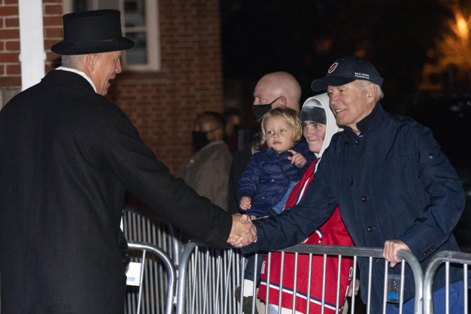 President Joe Biden shakes hands with the town crier after the Annual Christmas Tree Lighting ceremony at the top of Maine Street in Nantucket, Mass., Friday, Nov. 26, 2021. Standing with the president are Maisy Biden and Beau Biden. (AP Photo/Carolyn Kaster)