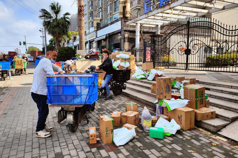 Parcels generated from the Double 11 online shopping spree pile up on the sidewalk outside a community delivery station in Shanghai, China Saturday, Nov. 12, 2022.