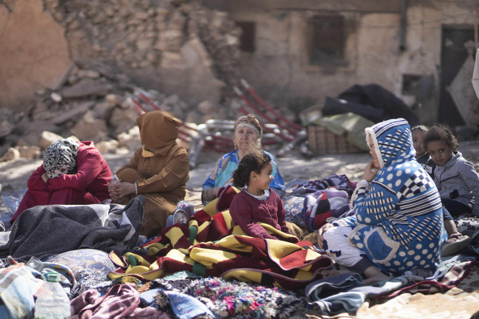 People sit outside following an earthquake in Marrakech, Morocco, on Saturday.